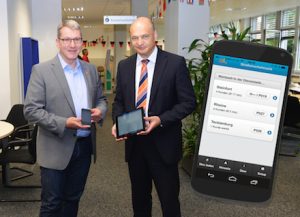 Landrat Dr. Klaus Effing (l.) und Kreisdirektor Dr. Martin Sommer präsentieren die neue App über Wartezeiten in den Kfz-Zulassungsstellen im Kreis Steinfurt.