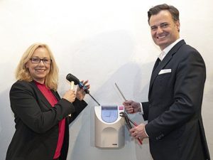 München: Gesamtpersonalratsvorsitzende Ursula Hofmann und Personalreferent Alexander Dietrich bauen die Stempeluhr ab.