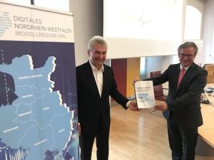 Paderborns Bürgermeister Michael Dreier (r.) übergibt eine Absichtserklärung an NRW-Wirtschaftsminister Andreas Pinkwart