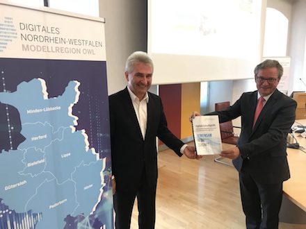 Paderborns Bürgermeister Michael Dreier (r.) übergibt eine Absichtserklärung an NRW-Wirtschaftsminister Andreas Pinkwart