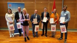 Hessens Digitalministerin Kristina Sinemus (3.v.l.) zeichnet die sechs Gewinnerinnen und Gewinner des KI-Ideenwettbewerbs aus.