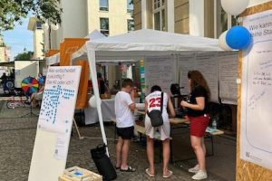 Offenbacherinnen und Offenbacher notieren am Stand auf dem Mainuferfest auf Plakaten