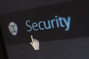Screenshot eines pixeligen Bildschirms. Zu sehen ist auf dunklem Grund die hellblaue Schrift "Security", eine Mauszeigerhand zeigt darauf.