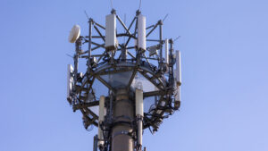 Mobilfunkmast aus der Untersicht aufgenommen gegen wolkenlosen blauen Himmel.