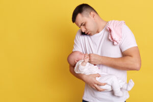 Junger Vater mit Kind im Arm.
