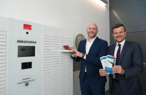 Olaf Kuch und Nürnbergs Oberbürgermeister Marcus König stehen vor einer Abholstation für Ausweisdokumente.