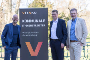 drei Personen neben Vitako-Schild