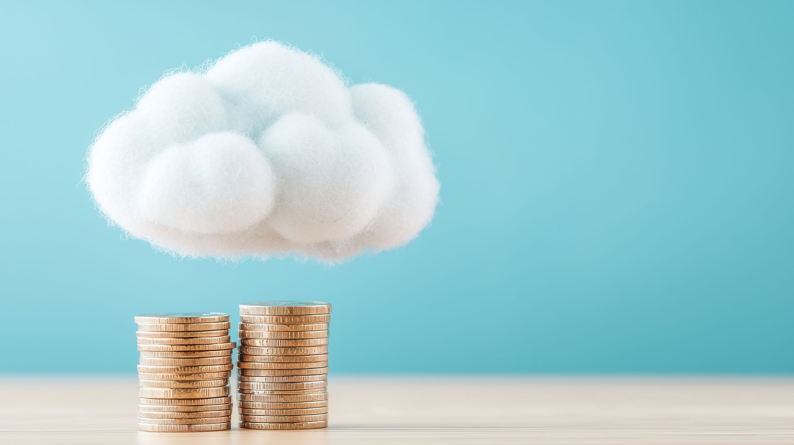 Eine Wolke schwebt über einem Stapel Münzgeld.