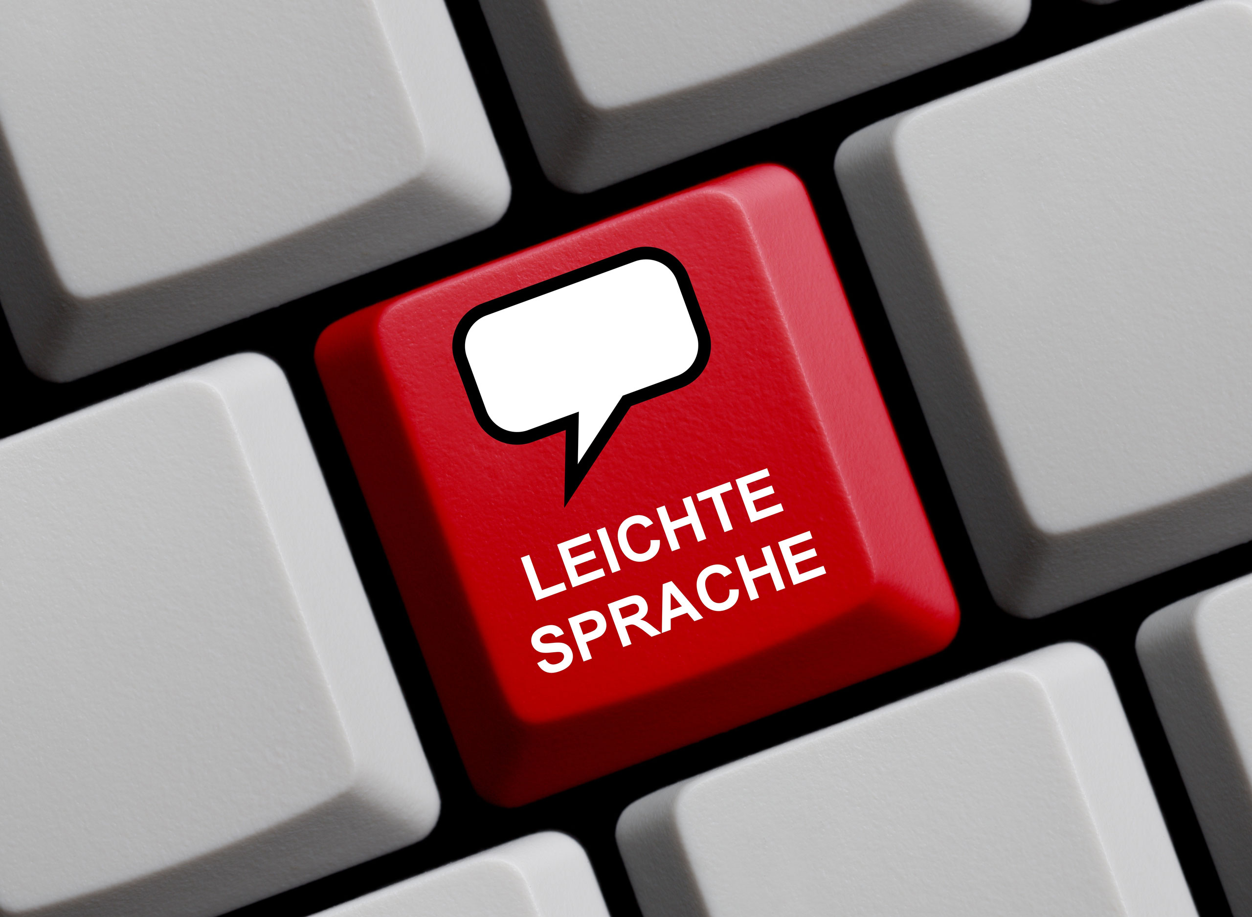 Ausschnitt einer Computertastatur, auf der eine Taste rot eingefärbt ist und die Aufschrift Leichte Sprache trägt.