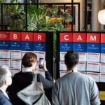 Kongressteilnehmer informieren sich an einer Infotafel über mögliche Barcamp-Themensessions.
