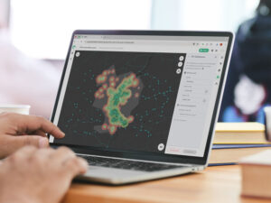 Aufgeklapptes Notebook mit Blick auf die Software GOAT sowie Hände einer Person auf der Tastatur.