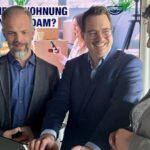 zwei Männer eine Frau vor einem Stehtisch