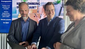 zwei Männer eine Frau vor einem Stehtisch