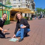 Julia Kuklik, Leiterin des Stadtarchivs Gütersloh, und Lena Jeckel, Leiterin des Fachbereichs Kultur, vor einem der QR-Codes auf dem Berliner Platz (Foto: Stadtarchiv).