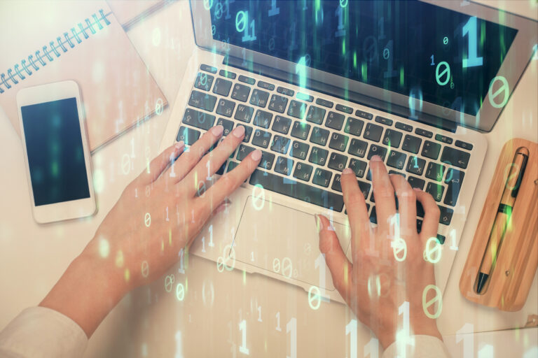 Frauenhände die auf einem Laptop tippen mit einem Overlay aus Binärcode.