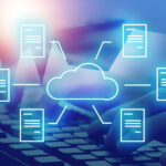 Verschiedene Dokumente sind mit einer Wolke verbunden, im Hintergrund sieht man eine Computertastatur.