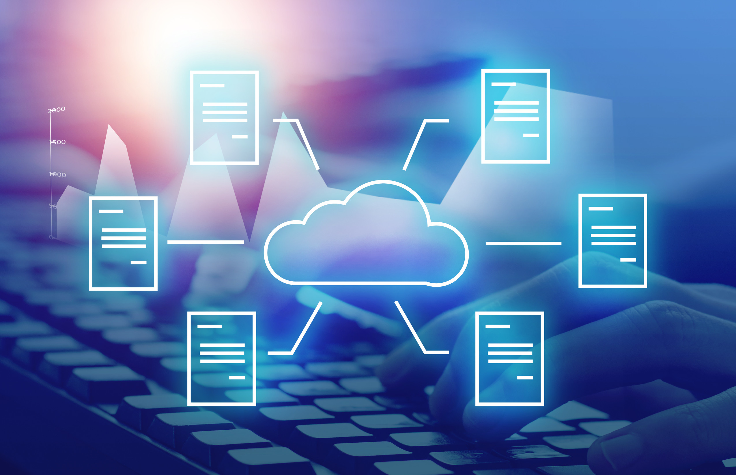 Verschiedene Dokumente sind mit einer Wolke verbunden, im Hintergrund sieht man eine Computertastatur.
