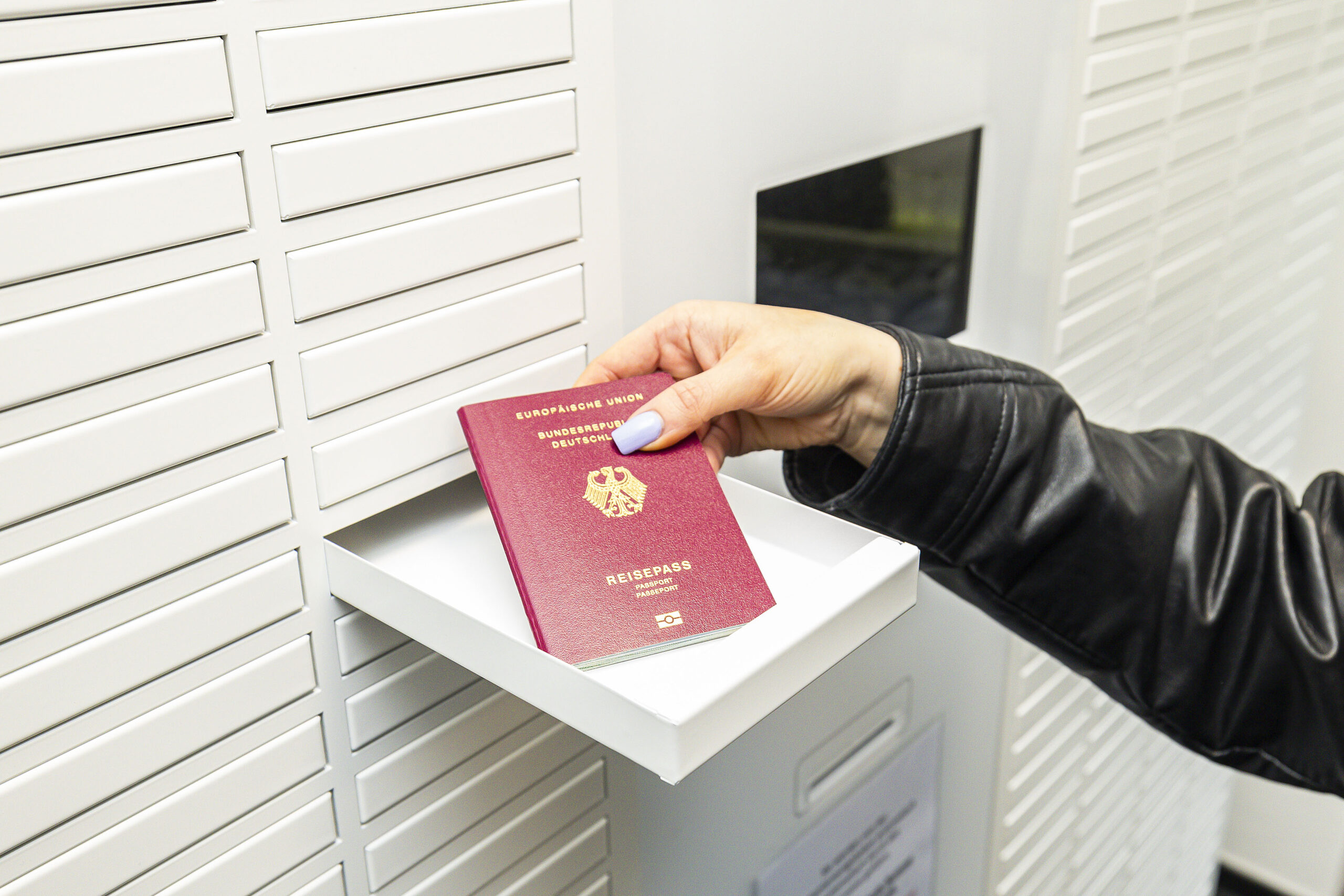 Hand holt Ausweisdokument aus DokBox ab