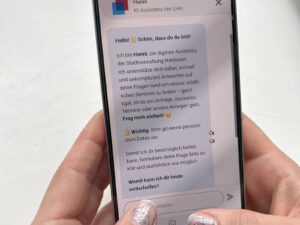 Auf einem Smartphone ist ein Chat mit der digitalen Assistenz Hanni zu sehen