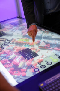 Eine Person zeigt mit dem Finger auf einen digitalen Stadtplan.