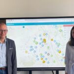 Vier Personen stehen vor einem Whiteboard, auf dem die digitale Spielplatzkarte der Stadt Emsdetten eingeblendet ist.