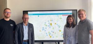 Vier Personen stehen vor einem Whiteboard, auf dem die digitale Spielplatzkarte der Stadt Emsdetten eingeblendet ist.
