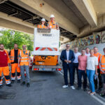 Mehere Personen stehen unter einer Brücke versammelt.