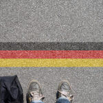 Eine Person steht an der Grenze zu Deutschland.