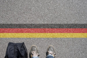 Eine Person steht an der Grenze zu Deutschland.
