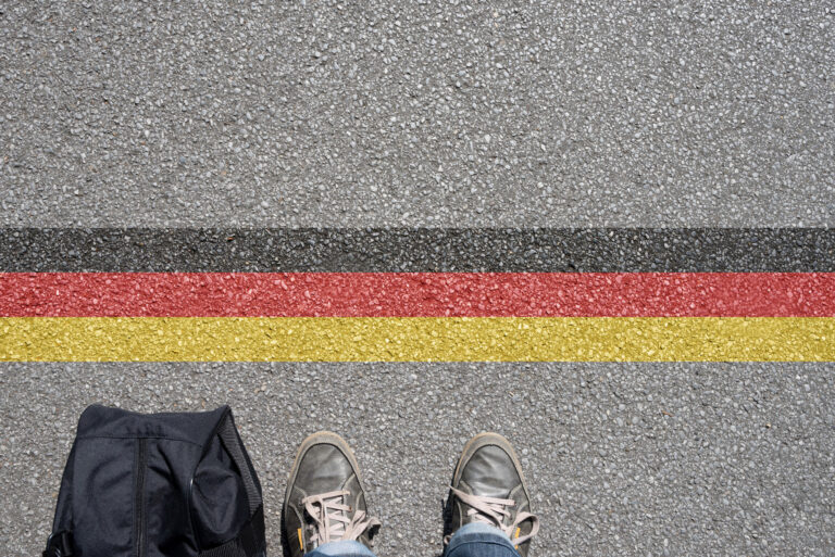 Eine Person steht an der Grenze zu Deutschland.