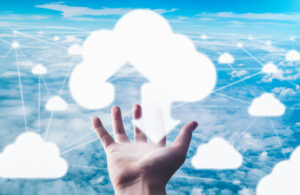 Eine Hand über der ein Wolkensymbol schwebt, das vernetzt ist mit anderen Wolkensymbolen.
