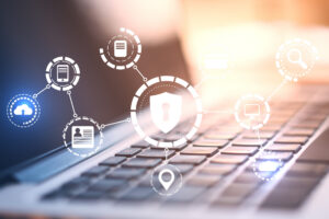 Verschwommen im Hintergrund die Nahaufnahme eines Laptops, über dessen Tastatur eine leuchtende digitale Vorhängeschloss-Schnittstelle schwebt.