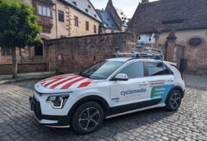 Ein mit Kamera und Laserscanner ausgestattetes Fahrzug von Cyclomedia steht vor einem historischen Gebäude.