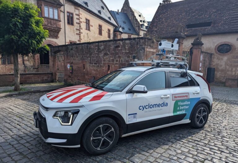 Ein mit Kamera und Laserscanner ausgestattetes Fahrzug von Cyclomedia steht vor einem historischen Gebäude.