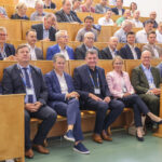 Mehrere Personen sitzen im Hörsaal einer Hochschule.
