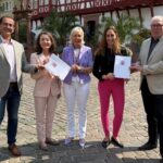 Mehrere Personen stehen nebeneinander und halten Förderbescheide in den Händen.