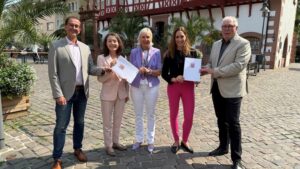 Mehrere Personen stehen nebeneinander und halten Förderbescheide in den Händen.