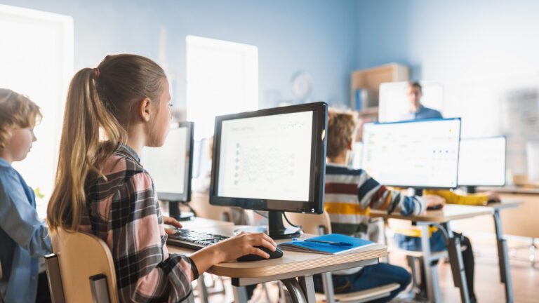 Schüler arbeiten in einem Klassenzimmer mit Computern.