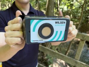 Eine Person hält einen Sensor in die Kamera.