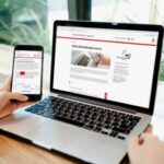 Laptop und Smartphone, auf deren Displays jeweils das Serviceportal der Stadt Lübeck zu sehen ist.
