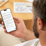 Ein Mann schaut in ein Smartphone, auf dem Informationen aus der Verwaltung zu sehen sind.