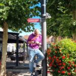 Ein Mann installiert einen Sensor an einer Straßenleuchte in einer Fußgängerzone.
