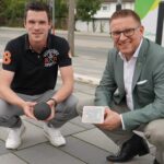 Matthias Frey hält einen Parkplatzsensor, Bürgermeister Robin Rieksneuwöhner einen Bodenfeuchtesensor in der Hand.