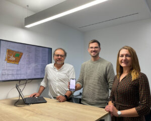 Drei Personen aus dem Bereich Bauordnung der Stadt Gütersloh neben einem Bildschirm am Tisch stehend