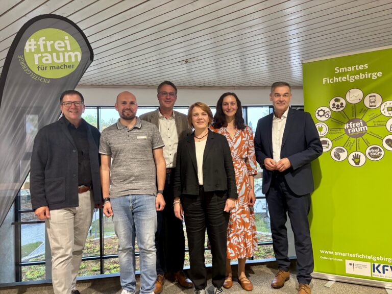 Gruppenfoto mit sechs Personen in einem nüchternen Innenraum, im Hintergrund Banner "Smartes Fichtelgebirge".