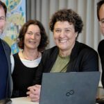 Vier Mitarbeitende der Stadt Potsdam versammeln sich um einen Laptop