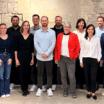 Gruppenfoto von einem Dutzend Personen vor einem alten Gewölbe