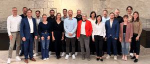 Gruppenfoto von einem Dutzend Personen vor einem alten Gewölbe