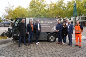 Eine Gruppe von Personen steht vor der smarten Kehrmaschine