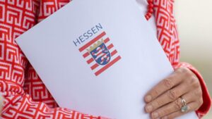 Ein Dokumentenordner mit dem hessischen Wappen in den Armen einer Frau.